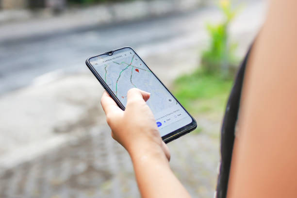 Bali,Indonesia, December 15, 2019 - Close up young woman using Google maps to check Covid - 19 community mobility reports to combat the virus spreading