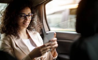 Businesswoman using smart phone in a car